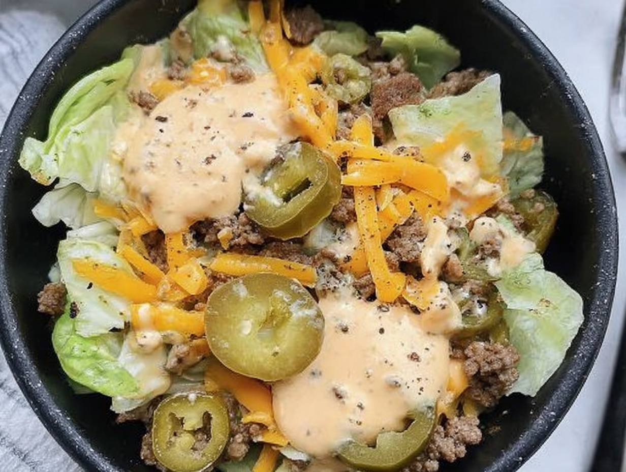 A close-up shot of the Big Mac Bowl, showing the ground beef, lettuce, cheese, pickles, and special sauce in a white bowl.