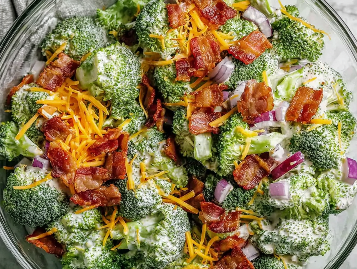 A large glass bowl of fresh broccoli salad, ready for meal prep.
